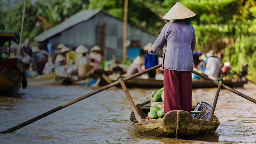 a lady rowing boat rowing along the mekong river